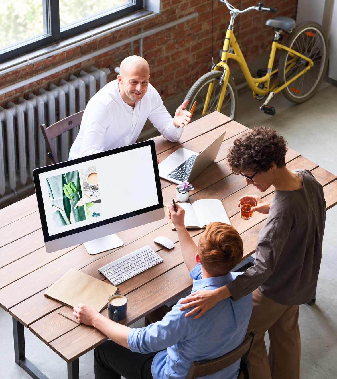 Three professionals discussing work around a desk